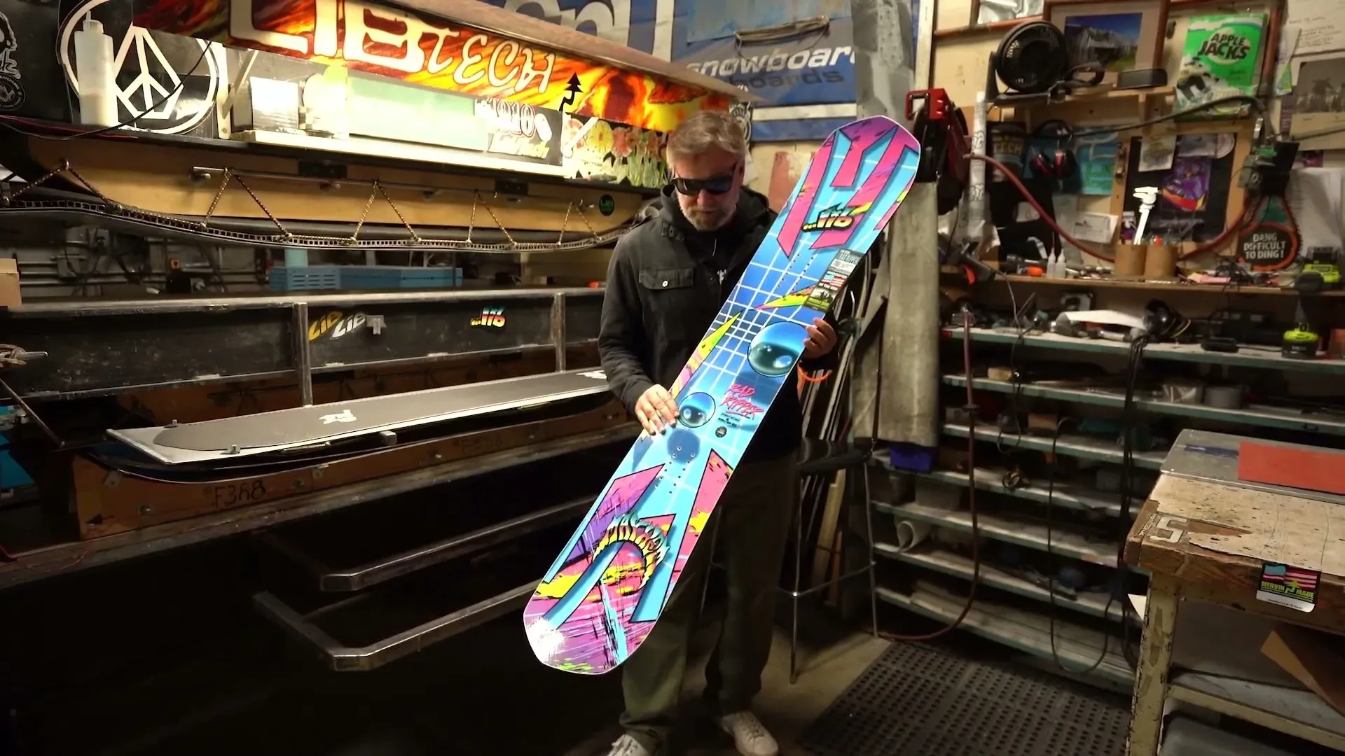 Matt Biolos държи синия Lib Tech Mayhem Rad Ripper в цеха на Mervin