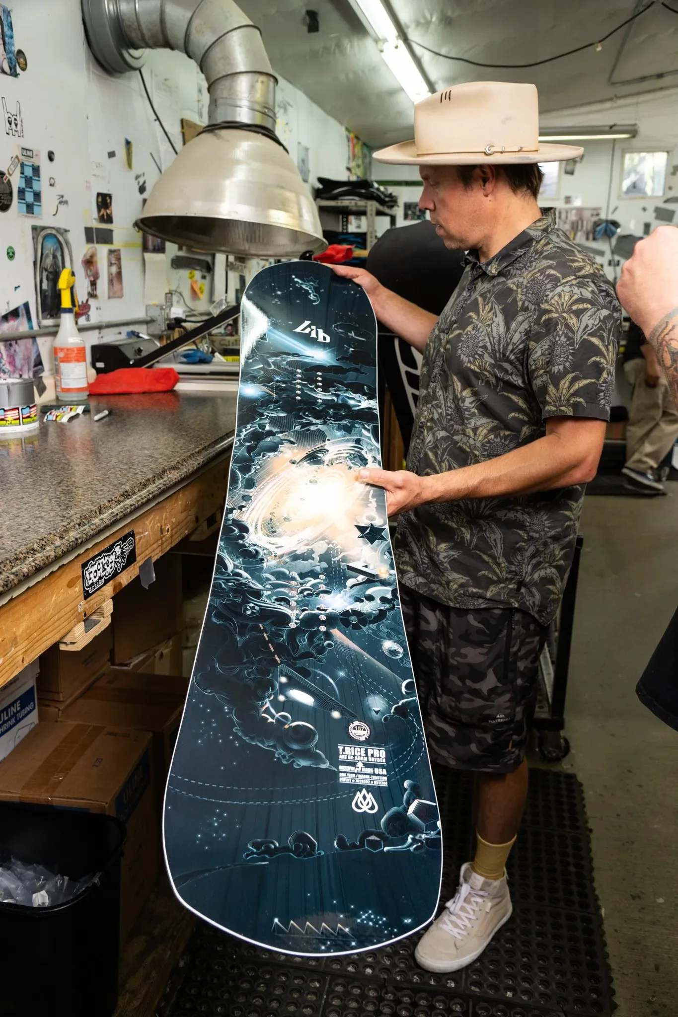 Travis Rice държи Lib Tech T.Rice Pro 2025 в цеха на Mervin